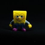 Close-up of a colorful Spongebob toy figure against a black background.